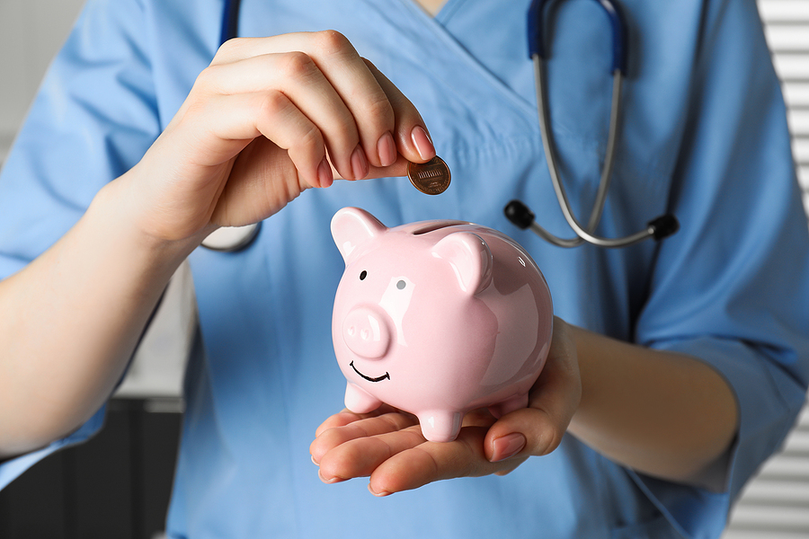 Nurse educator putting coin into piggy bank